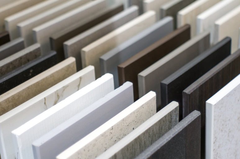 A neatly arranged collection of square samples comprised of different stone materials to use in building a countertop.